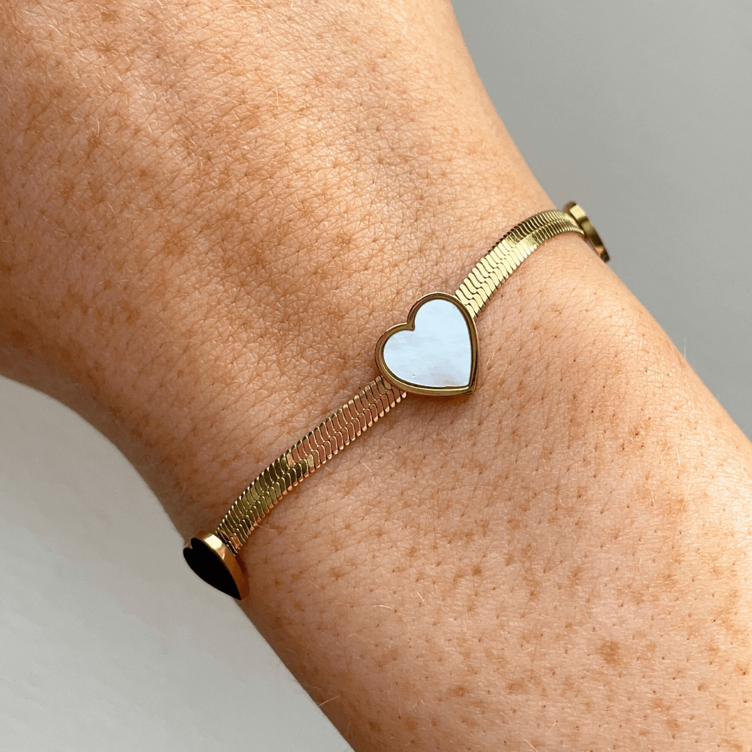 Say hello to love with our White and Gold Three Heart Bracelet! 🫶💖 This charming piece adds a touch of romance and elegance to any outfit. Crafted from 18K gold plated stainless steel, it’s water-resistant, tarnish-free, and nickel-free. P.S. If you’re