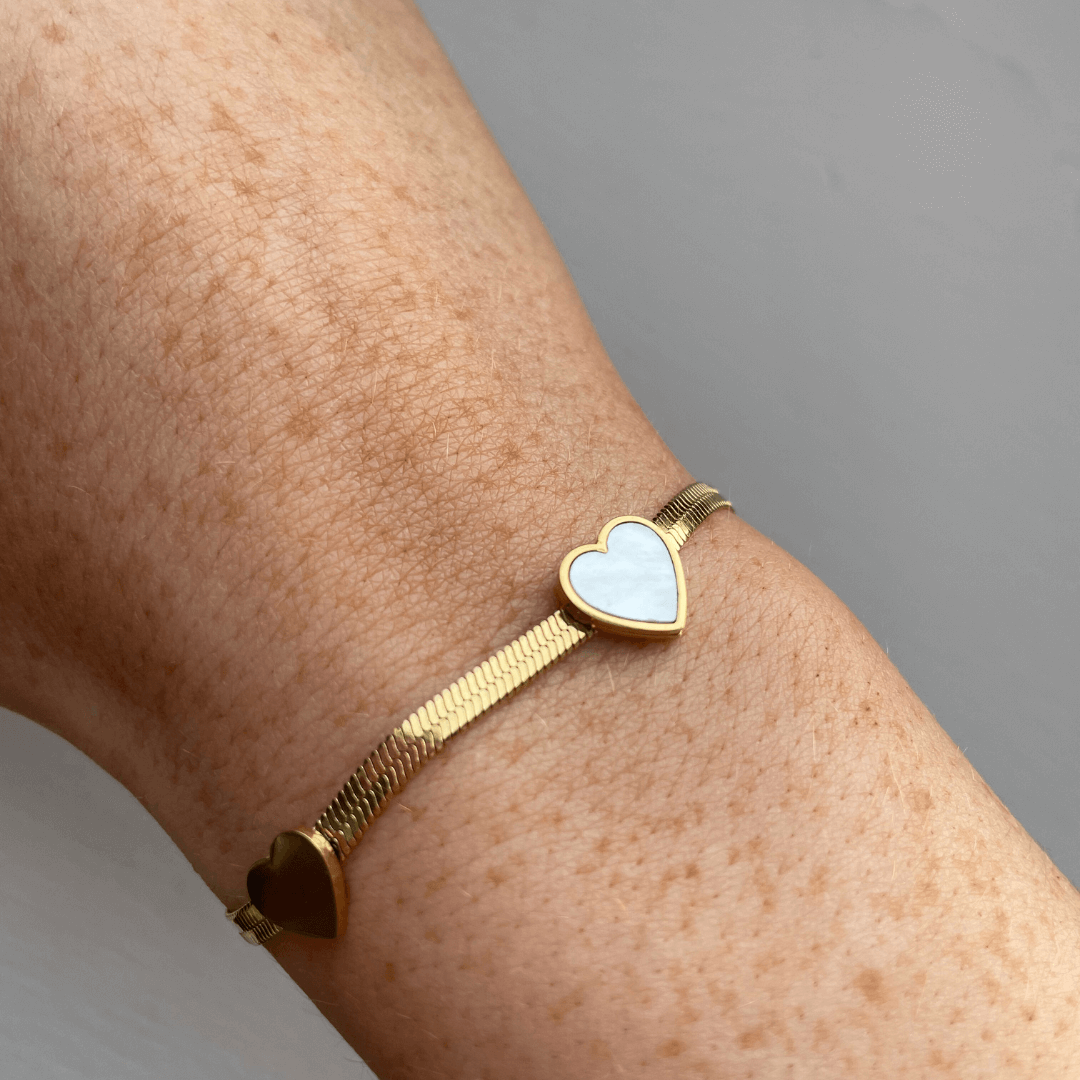 Say hello to love with our White and Gold Three Heart Bracelet! 🫶💖 This charming piece adds a touch of romance and elegance to any outfit. Crafted from 18K gold plated stainless steel, it’s water-resistant, tarnish-free, and nickel-free. P.S. If you’re