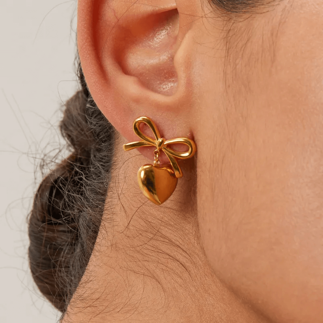 Featuring a gorgeous bow and heart design, the Sian Earrings are your new must-have accessory! 🎀❤️ Crafted from 18K gold plated stainless steel, they’re water-resistant, tarnish-free, and nickel-free. P.S. If you’re gifting them, don’t forget to add a gi