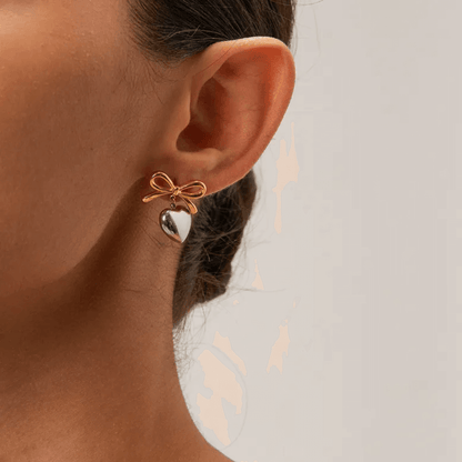 Featuring a gorgeous bow and heart design, the Sian Earrings are your new must-have accessory! 🎀❤️ Crafted from 18K gold plated stainless steel, they’re water-resistant, tarnish-free, and nickel-free. P.S. If you’re gifting them, don’t forget to add a gi