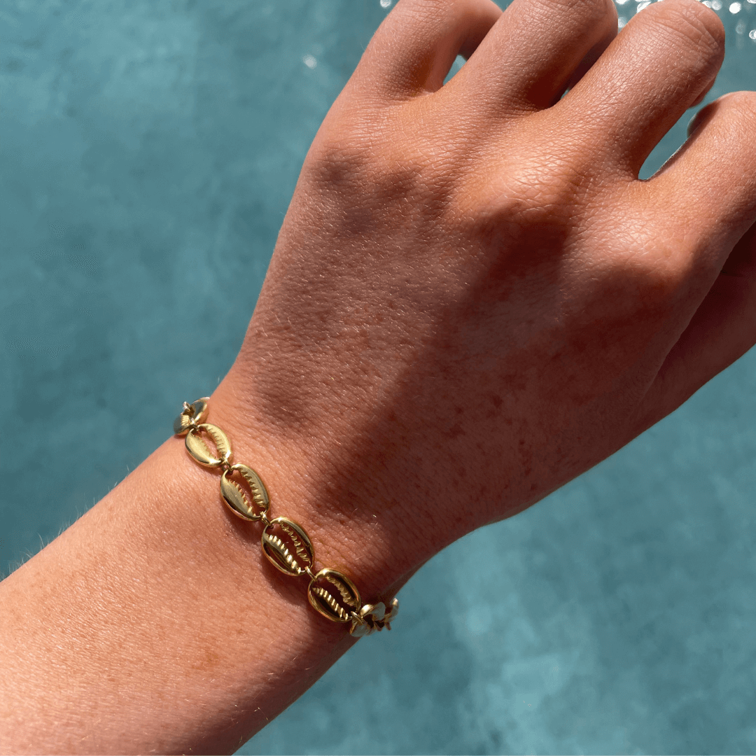 Add a touch of coastal charm with the Shell Bracelet! 🌊 This piece features a unique design inspired by the beauty of the sea, making it the perfect accessory for a laid-back, stylish look. Crafted from 18K gold plated stainless steel, it’s water-resista